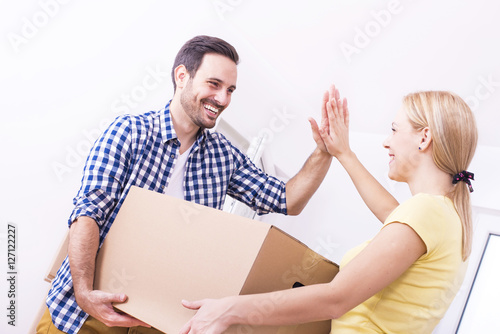 Young couple moving in to new home together. Home, people, moving and real estate concept