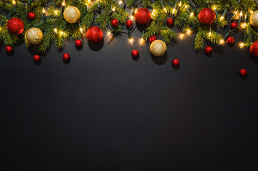 Christmas decoration background over black chalkboard, top view. Horizontal photo of decorations taken from above with copy space for text and other web or print design elements.