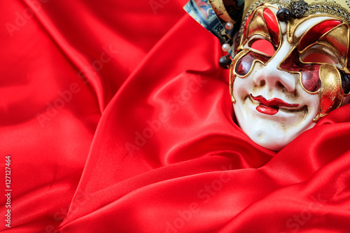 Carnival mask on red satin background