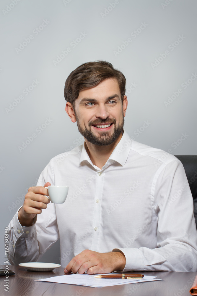 Young handsome businessman smiling with cup of coffee Young handsome businessman smiling with cup of coffee