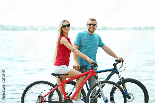 Happy couple with bicycles on the beach