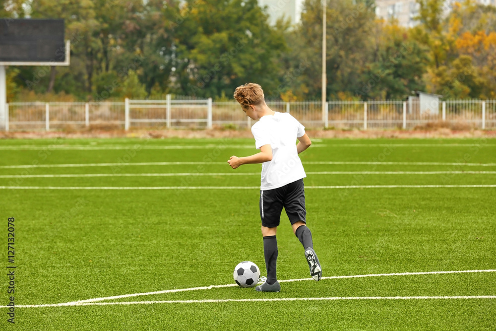 Boy playing football at stadium Boy playing football at stadium