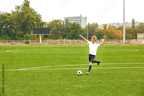 Boy playing football at stadium