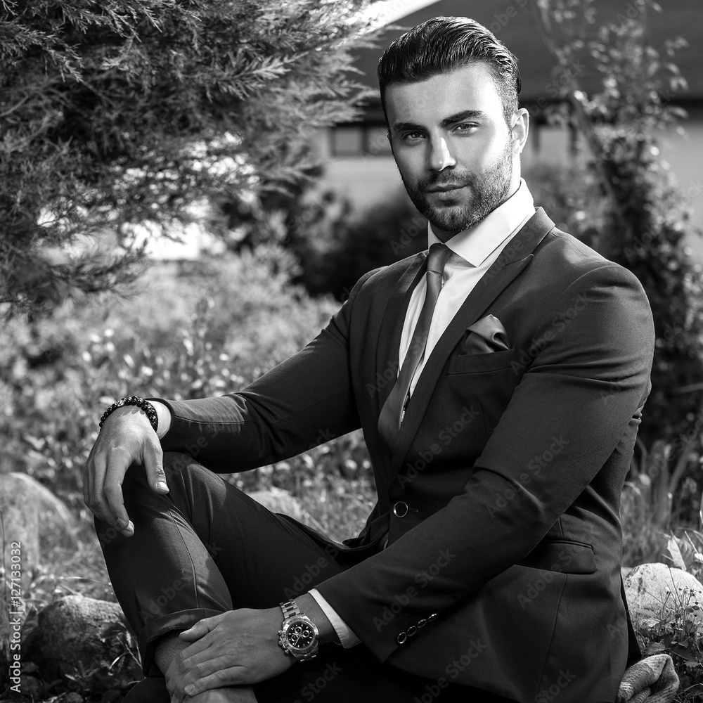 Black-white outdoor portrait of elegant handsome man in classical suit. Black-white outdoor portrait of elegant handsome man in classical suit.