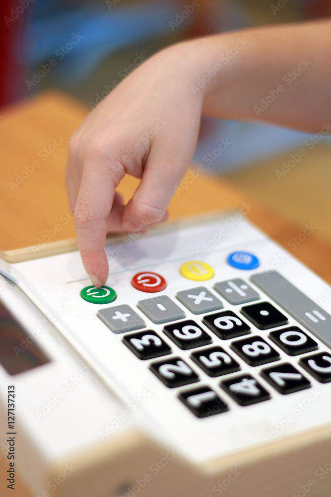 Children's hand presses on button calculator Children's hand presses on button calculator