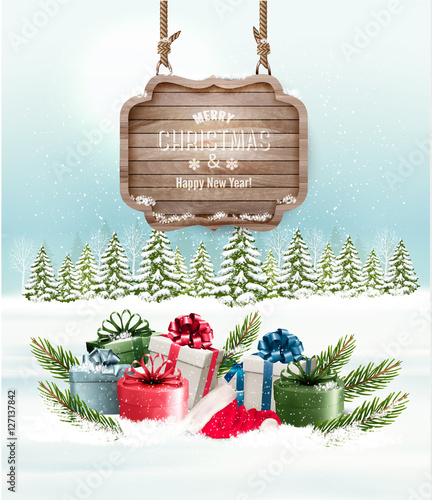 Winter background with gift boxes and a wooden ornate Merry chri