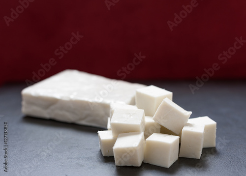 Canvas Print Buffalo paneer Indian cheese on black slate cutting chopping board counter in on