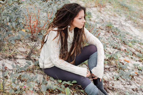 attractive young woman in white sweater outdoors