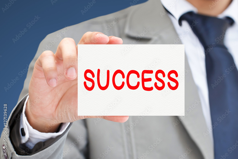 Businessman hand holding card with success message. Businessman hand holding card with success message.