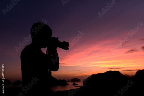 Photographer silhouette shooting seaand landscape outdoors at s