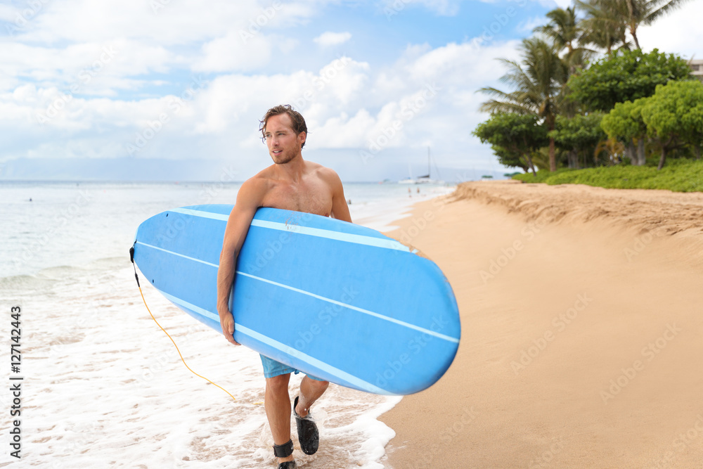 Surfer man going surfing on maui beach hawaii, usa. Professional male