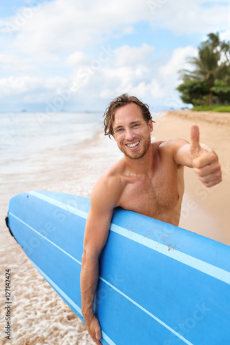 Photography Surfer guy happy with surf surfing smiling doing thumbs up hand sign at camera after fun surf session in ocean waves on beach vacation