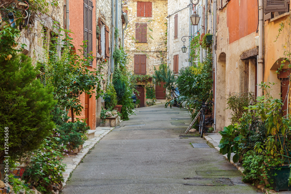 Fototapeta Ulica z kwiatami na starym mieście we Francji.