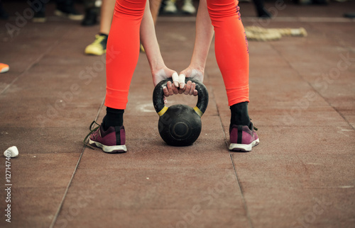 Woman athlete holding a kettlebell close up