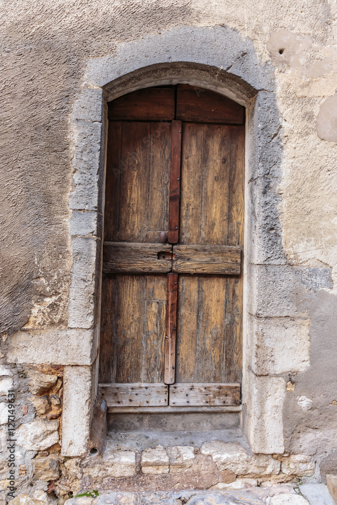Old wooden door in the entrance stone French house Old wooden door in the entrance stone French house