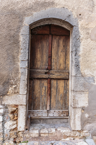 Old wooden door in the entrance stone French house © arbalest