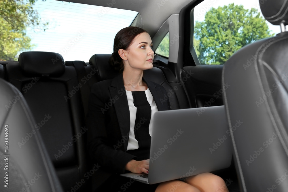 Beautiful woman with laptop in car