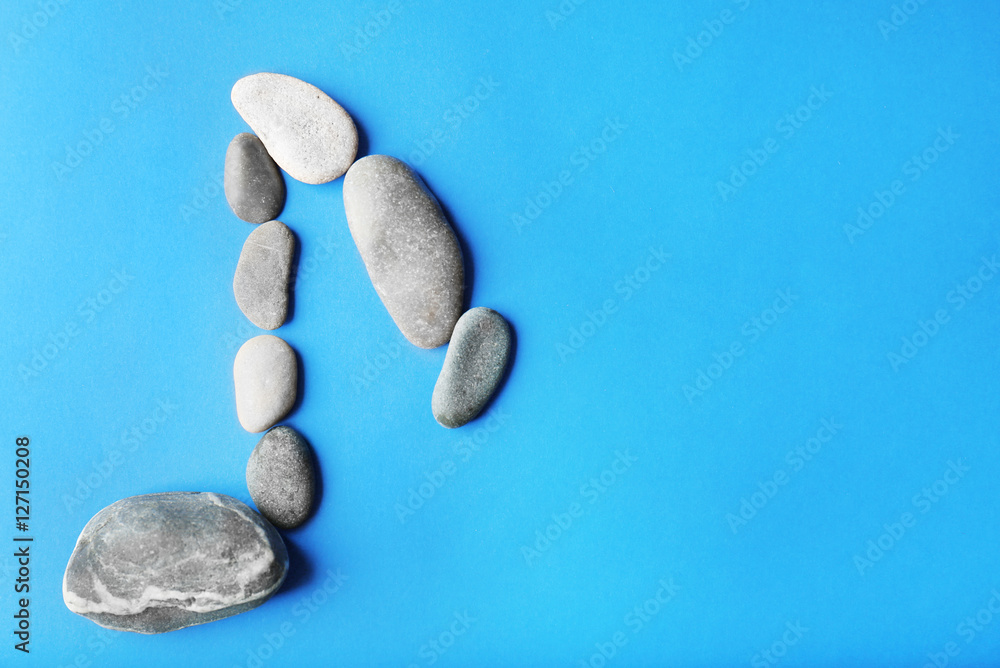 Music note sign made of stones on blue background Music note sign made of stones on blue background