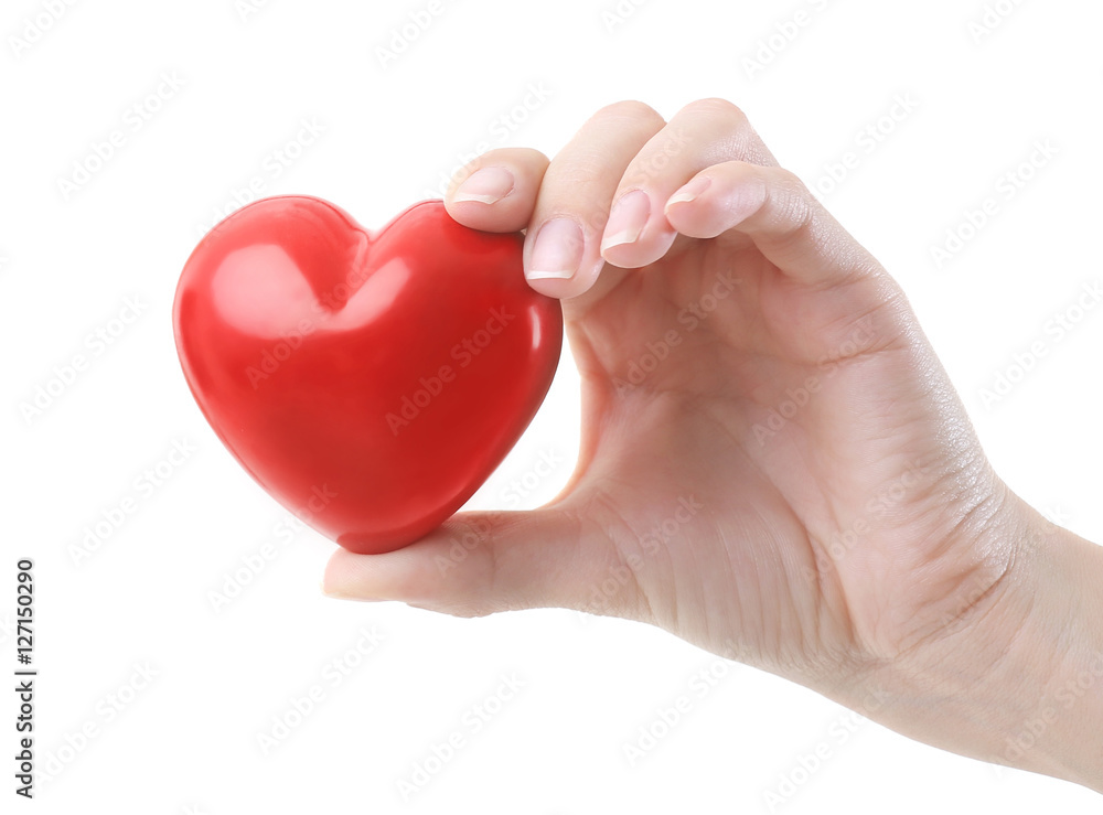 Female hand holding little ceramic heart on white background Female hand holding little ceramic heart on white background