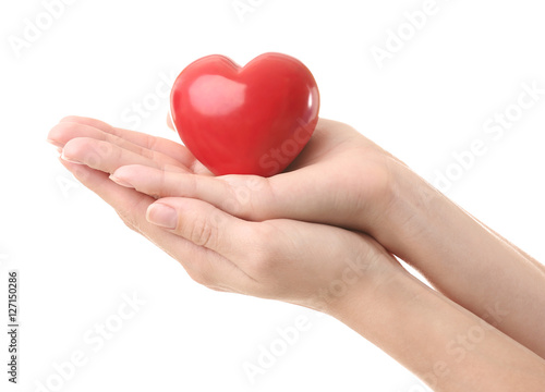 Female hands holding little ceramic heart on white background