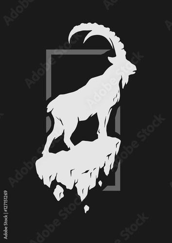 Silhouette of a mountain goat standing on a rock.