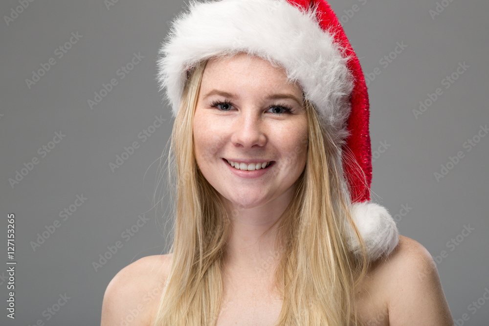 Hübsches lachendes Mädchen mit Weihnachtsmütze Hübsches lachendes Mädchen mit Weihnachtsmütze
