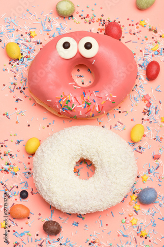 Funny glazed donuts on pink background