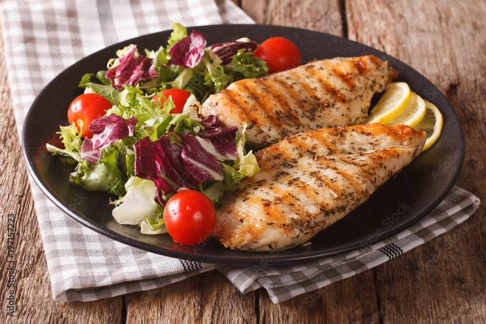 roasted Chicken breast with mix salad of chicory, tomatoes and lettuce close-up. Horizontal roasted Chicken breast with mix salad of chicory, tomatoes and lettuce close-up. Horizontal