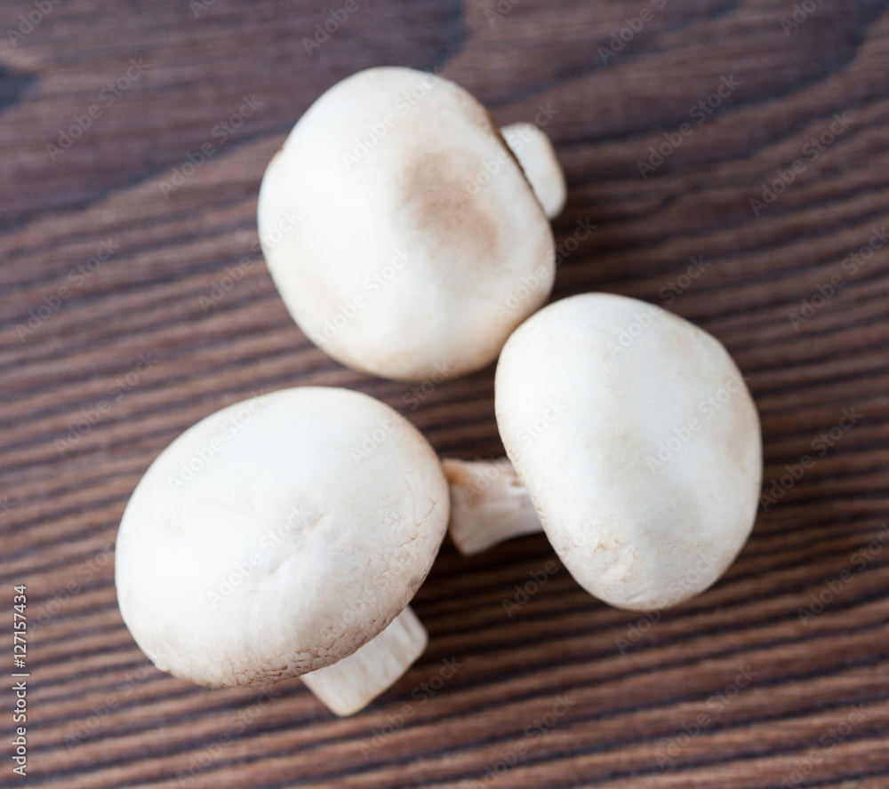 White mushrooms on wooden background White mushrooms on wooden background