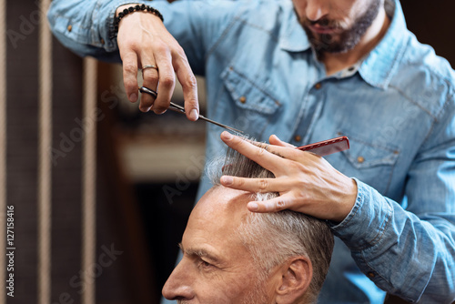 Closeup of senior man having haircut in barbershop