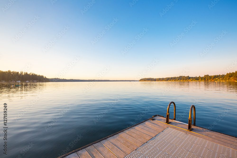 Fototapeta premium Wooden pier on lake sunset and sky reflection water.