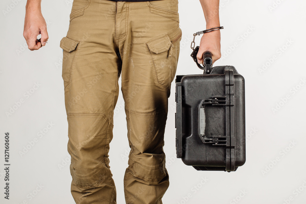 guard hand in handcuffs close up holding case with money guard hand in handcuffs close up holding case with money