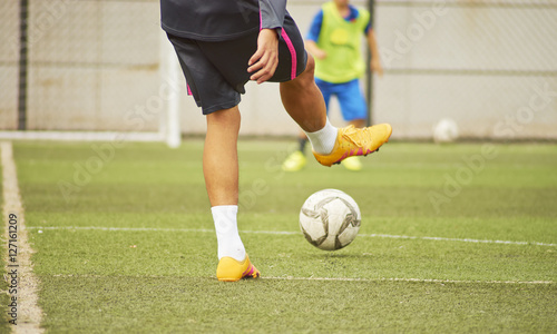 soccer players practicing passing ball in pitch