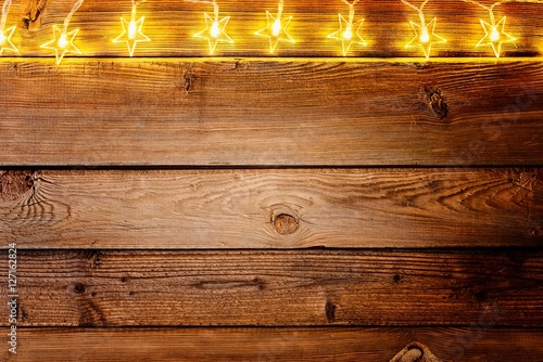 Christmas lights on wooden rustic background.