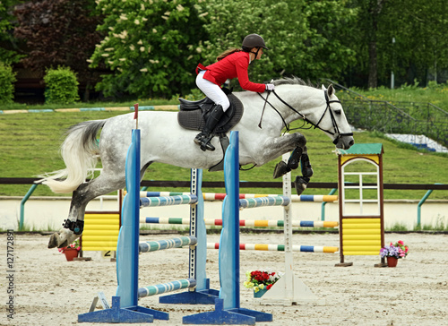 Equestrian girl horseback jumping obstacle