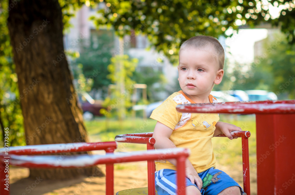 Happy smiling and handsome boy kid having fun playing at playground in a park on bright sunny day Happy smiling and handsome boy kid having fun playing at playground in a park on bright sunny day