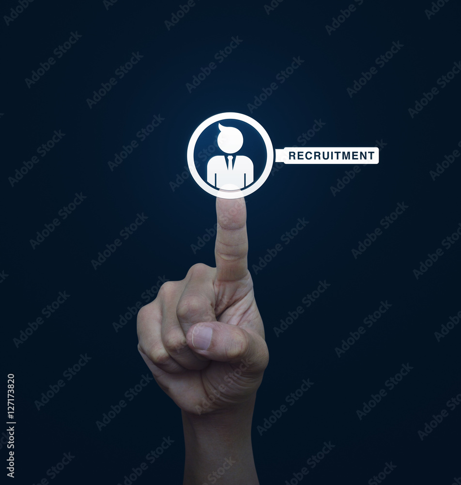 Hand pressing businessman with magnifying glass icon over blue b Hand pressing businessman with magnifying glass icon over blue b