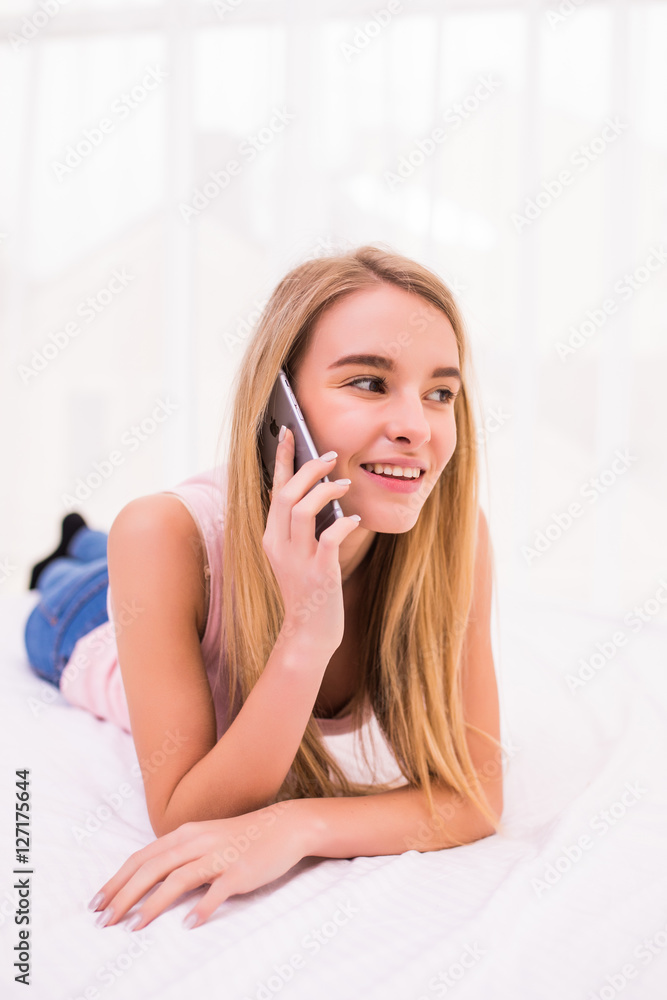 young blonde girl speak phone in her bed at home young blonde girl speak phone in her bed at home