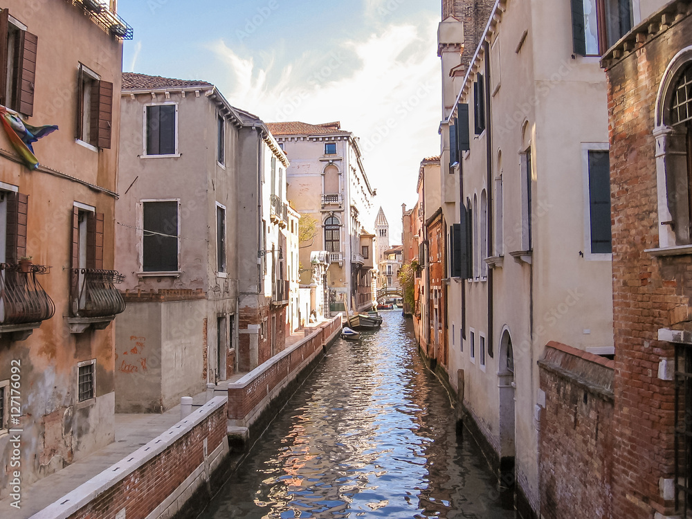 Traditional boats on canals of Venice through Venetian alleys. Italian city of Unesco Heritage.