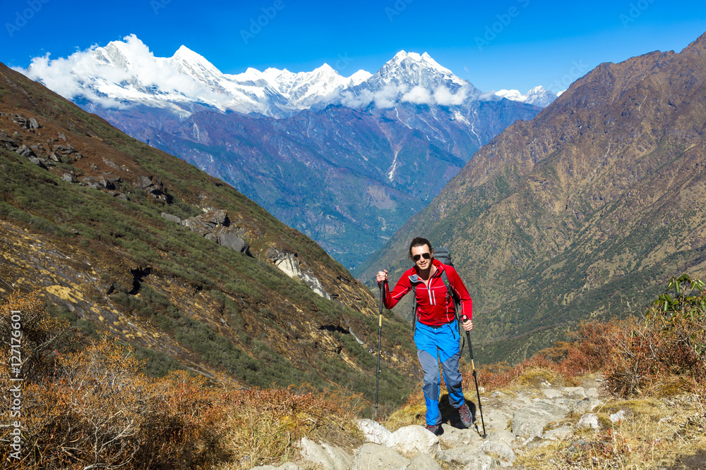 One young Hiker walking on Mountain Trail Peaks on Background One young Hiker walking on Mountain Trail Peaks on Background