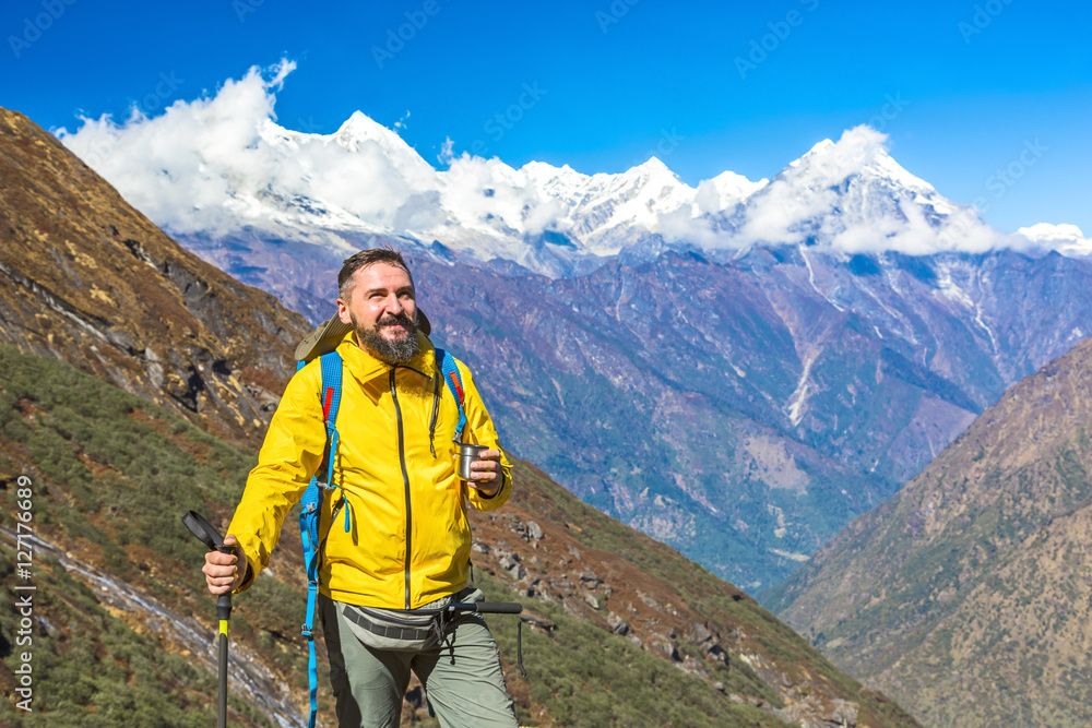 Bearded mature Hiker holding Tea Mug and walking Pole