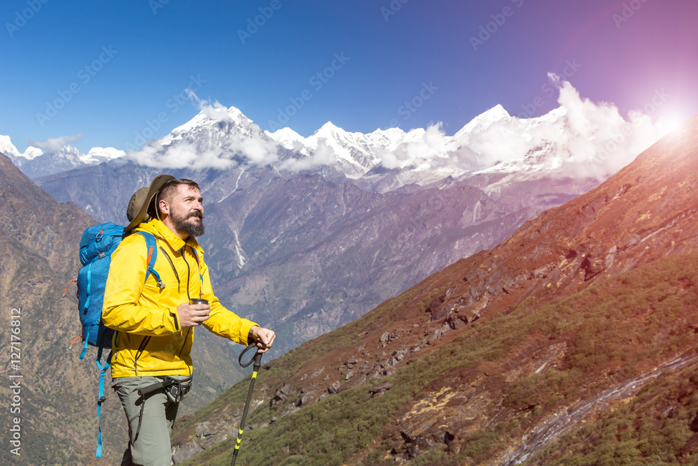 Hiker in yellow Jacket drinking Tea in Mountains Sun shining