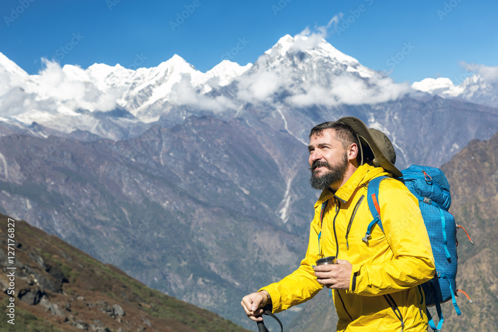 Portrait of bearded Hiker in yellow Jacket enjoying Mountain View