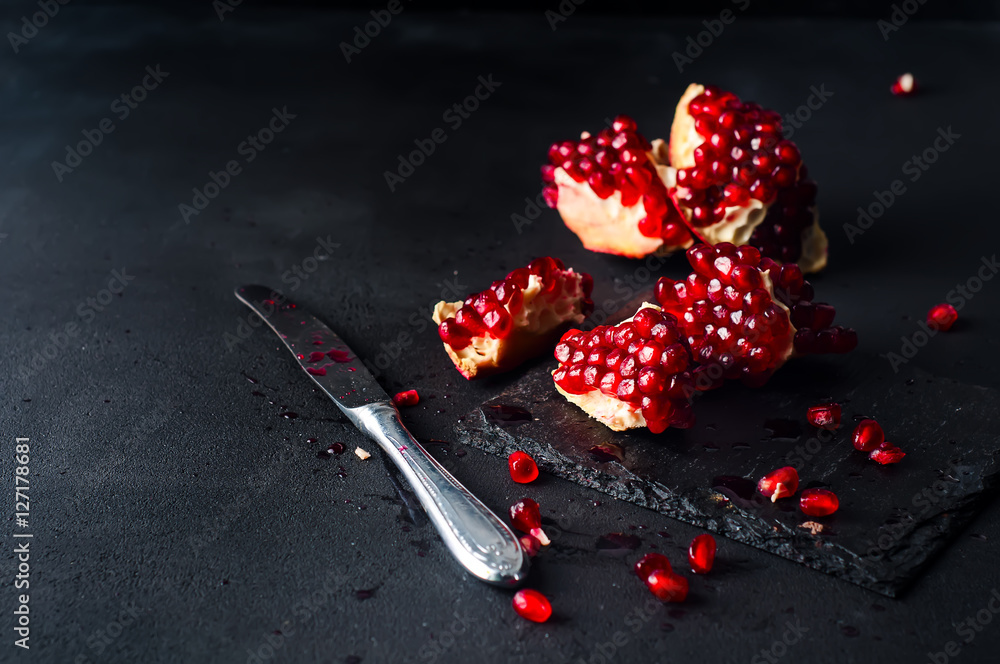 Pomegranates and pomegranate seeds on a dark background Pomegranates and pomegranate seeds on a dark background