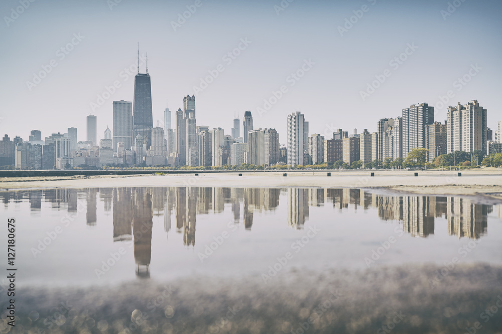 Retro old film stylized Chicago city skyline reflected in a puddle, USA.