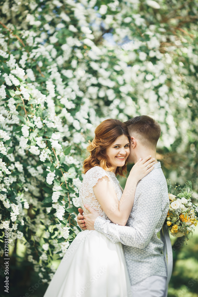 Happy wedding couple walking in a botanical park