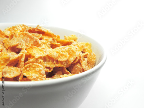 cornflakes in a white bowl, isolated on white background.