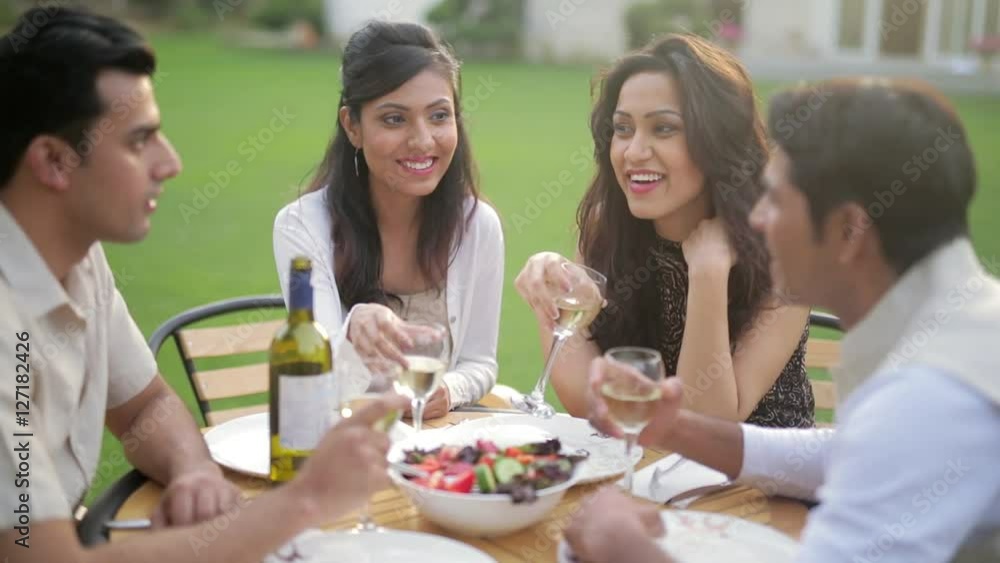 MS SELECTIVE FOCUS Couples talking during dinner in backyard / India MS SELECTIVE FOCUS Couples talking during dinner in backyard / India
