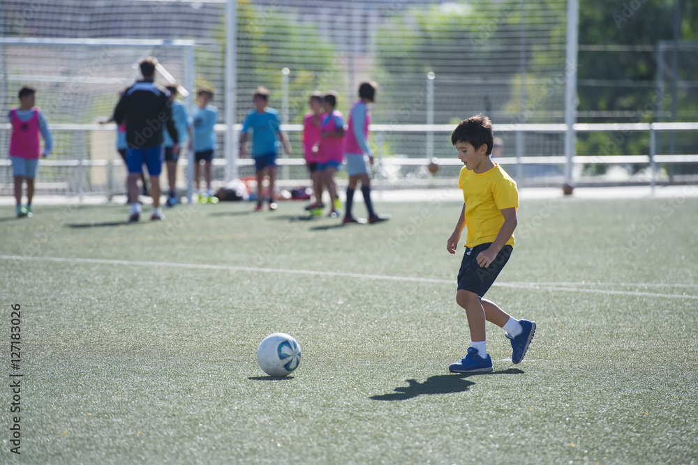 Fototapeta premium Niño en un entrenamiento de fútbol 7, deportes de equipo para actividades extraescolares