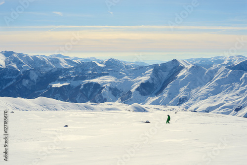 Panorama of winter mountains, with the snowboarders
